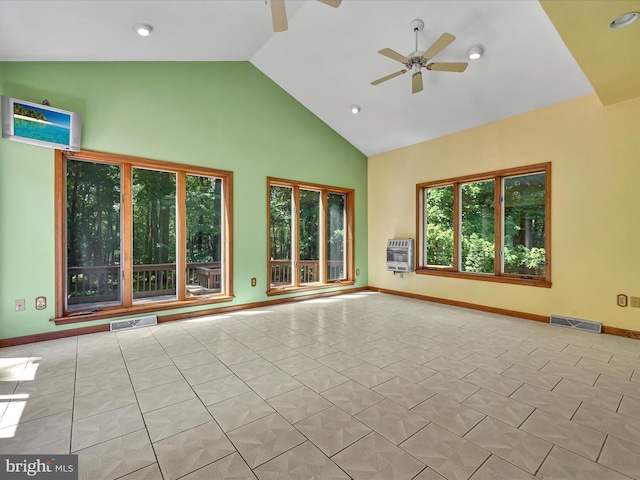 empty room with heating unit, ceiling fan, high vaulted ceiling, and light tile patterned floors