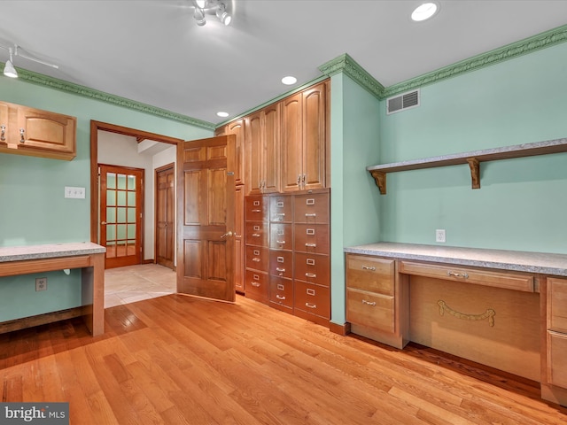 interior space featuring french doors, built in desk, light hardwood / wood-style flooring, and ornamental molding