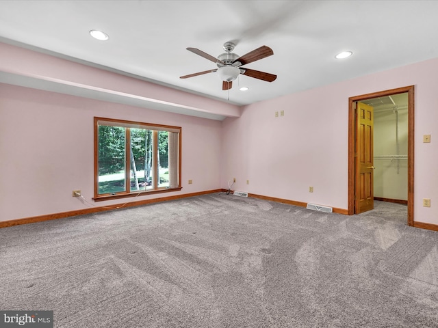 carpeted spare room with ceiling fan