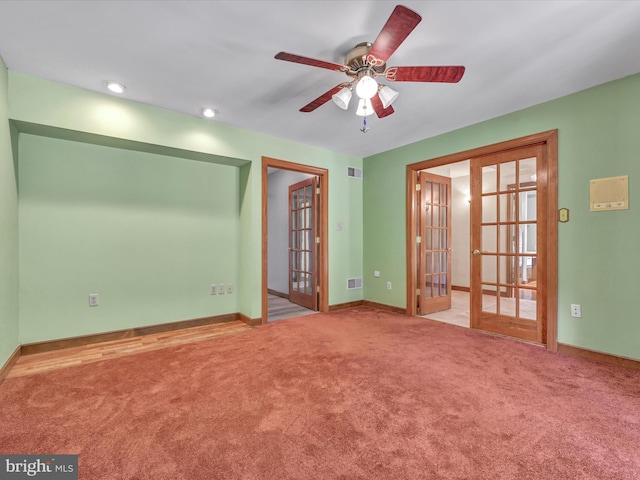 empty room featuring ceiling fan, light carpet, and french doors