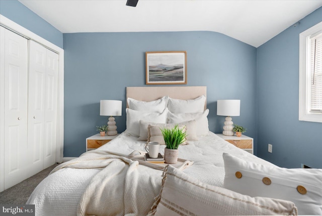 carpeted bedroom with multiple windows, ceiling fan, a closet, and vaulted ceiling