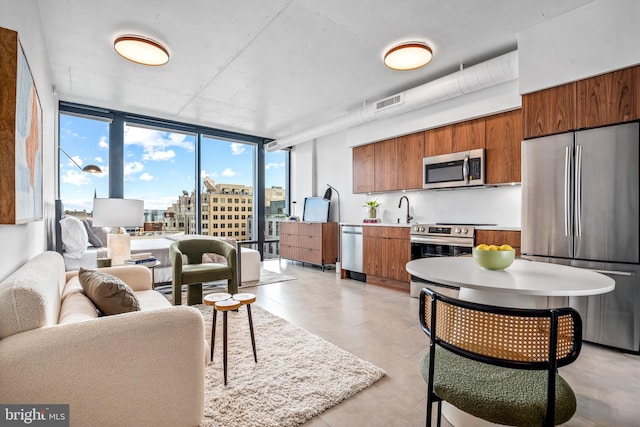 kitchen featuring floor to ceiling windows, sink, and stainless steel appliances