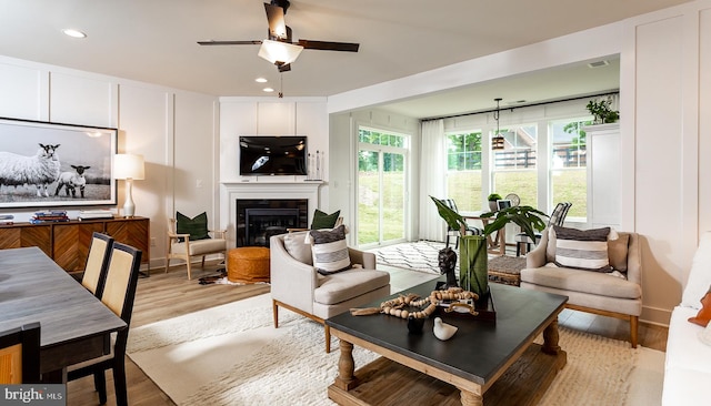 living room with light wood-type flooring and ceiling fan