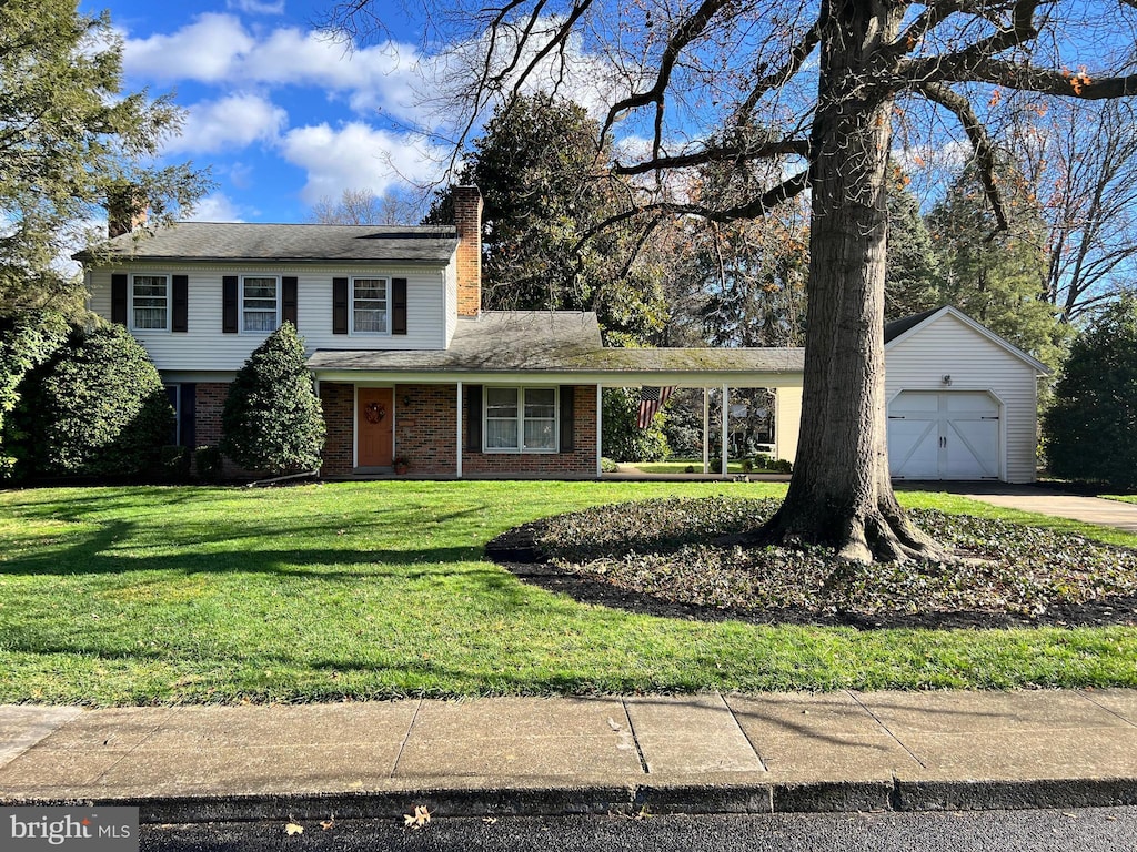 view of front of property featuring a front lawn, an outdoor structure, and a garage