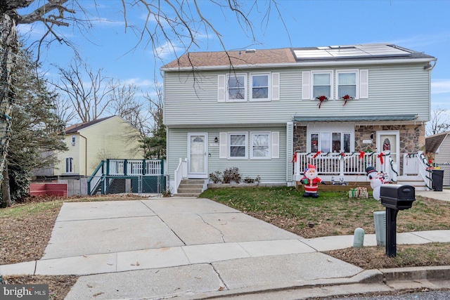 view of front facade with a front yard and solar panels