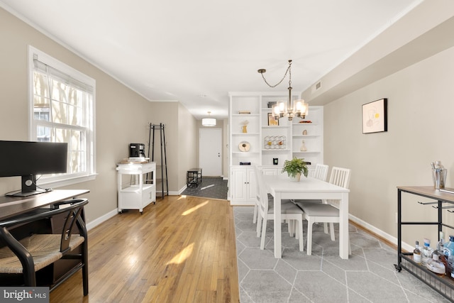 dining room with light hardwood / wood-style floors and an inviting chandelier