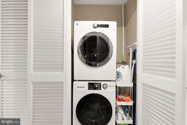 clothes washing area with stacked washer and dryer