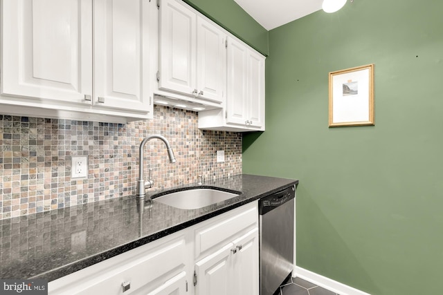 kitchen with white cabinetry, sink, tasteful backsplash, stainless steel dishwasher, and dark stone countertops