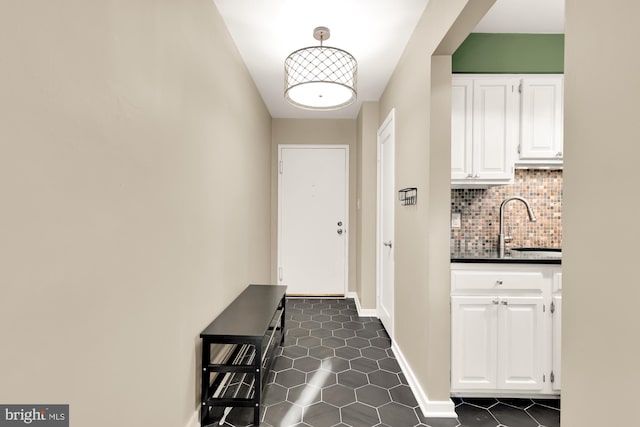 doorway to outside featuring dark tile patterned flooring and sink