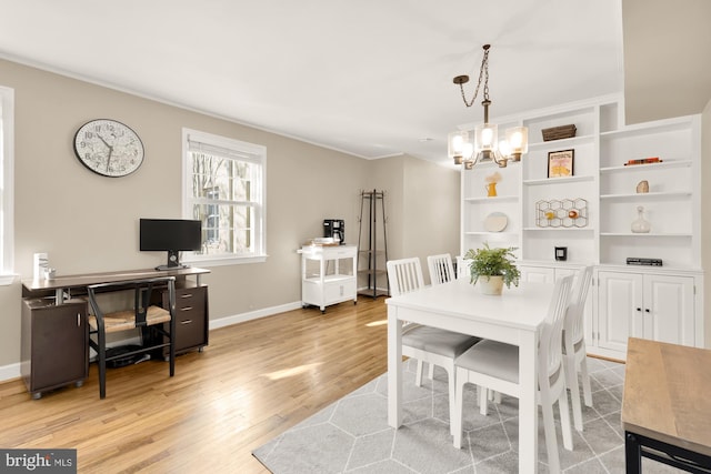 dining room featuring crown molding, a chandelier, and light wood-type flooring