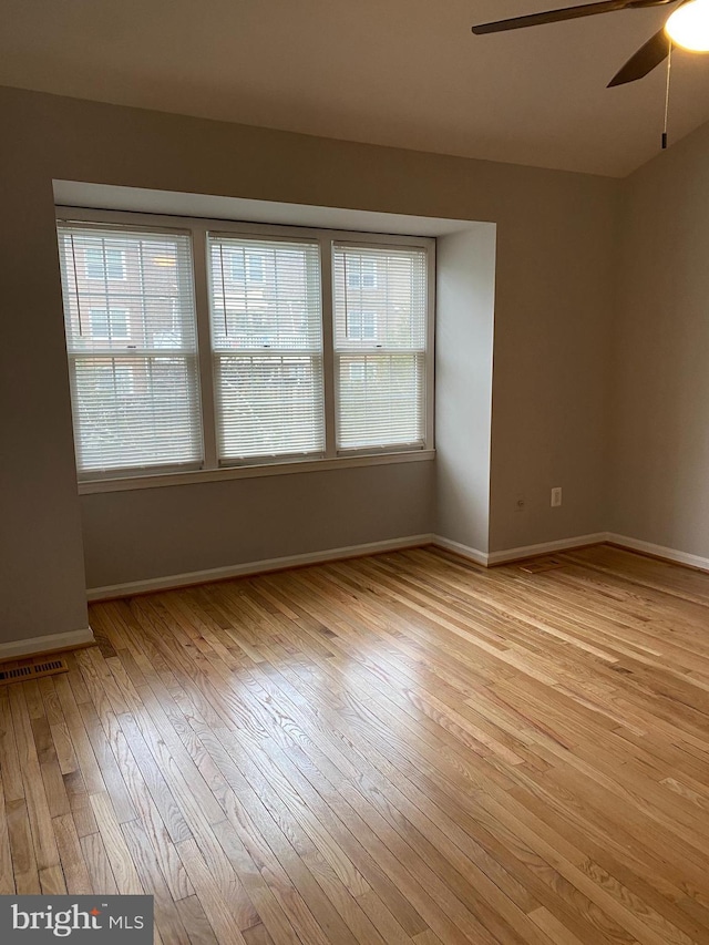 unfurnished room featuring plenty of natural light, ceiling fan, and light hardwood / wood-style flooring