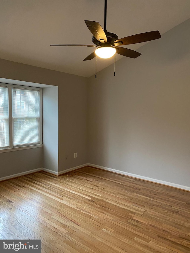 empty room featuring light hardwood / wood-style flooring, vaulted ceiling, and ceiling fan