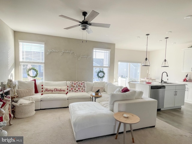 living room with ceiling fan, light wood-type flooring, plenty of natural light, and sink