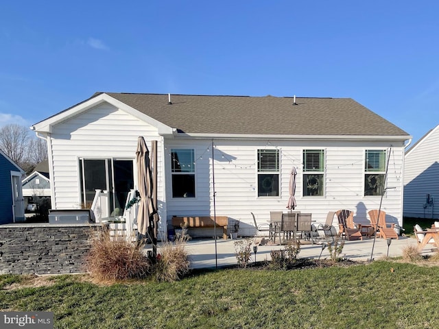 back of property with a yard, a patio area, and exterior kitchen