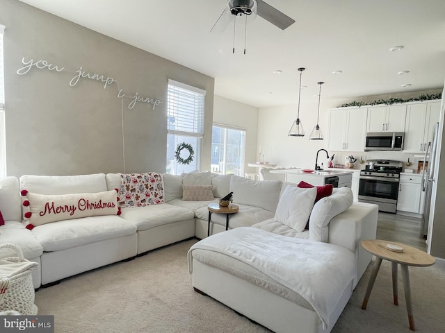 living room featuring ceiling fan and sink