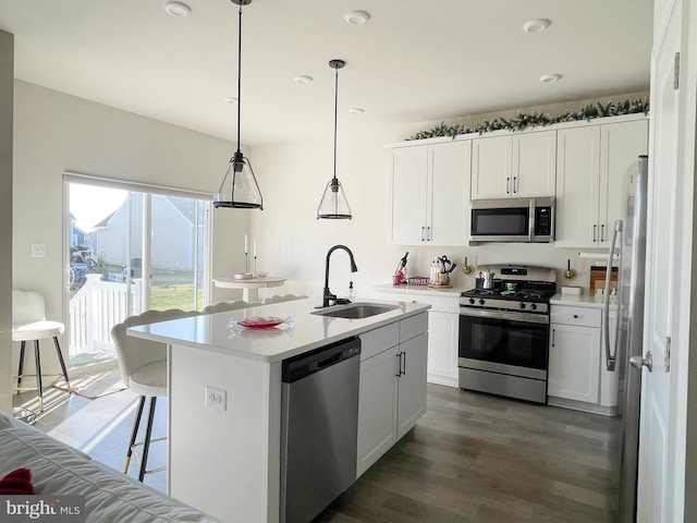 kitchen with a center island with sink, white cabinets, sink, and appliances with stainless steel finishes