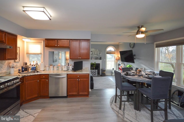 kitchen featuring dishwasher, light hardwood / wood-style floors, black stove, and plenty of natural light