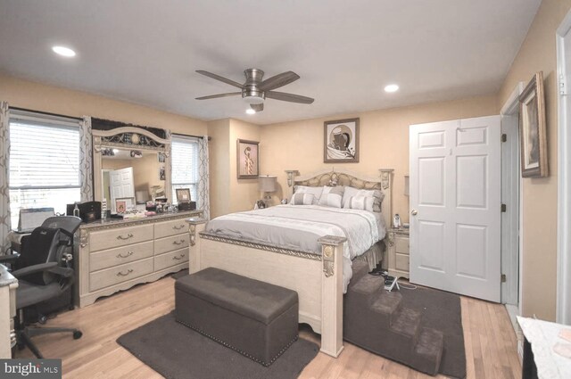 bedroom featuring light hardwood / wood-style floors, multiple windows, and ceiling fan