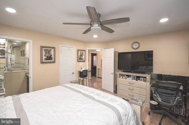 bedroom with hardwood / wood-style flooring, ceiling fan, and ensuite bath