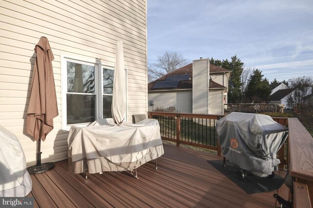 wooden deck featuring a grill