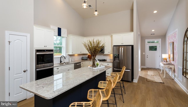 kitchen featuring white cabinetry, high vaulted ceiling, and appliances with stainless steel finishes