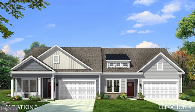 view of front of home with covered porch, a garage, and a front lawn