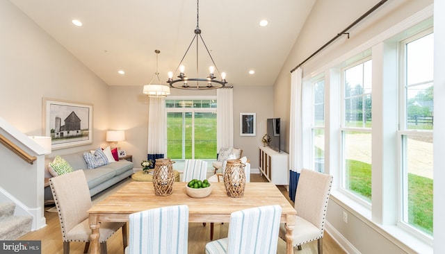 dining space with light hardwood / wood-style floors, a wealth of natural light, and lofted ceiling