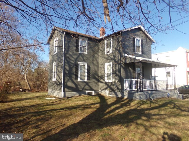 back of house with a yard and covered porch