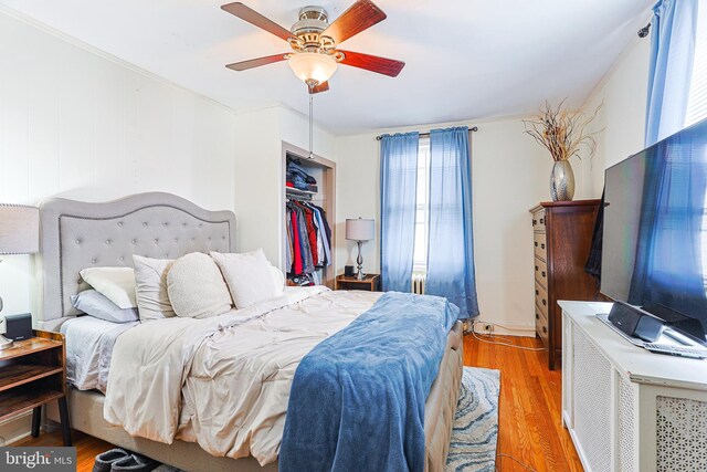 bedroom featuring multiple windows, wood-type flooring, a closet, and ceiling fan