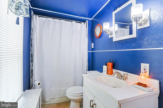 bathroom with tile patterned flooring, vanity, curtained shower, and toilet