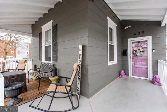 view of exterior entry featuring a porch and cooling unit