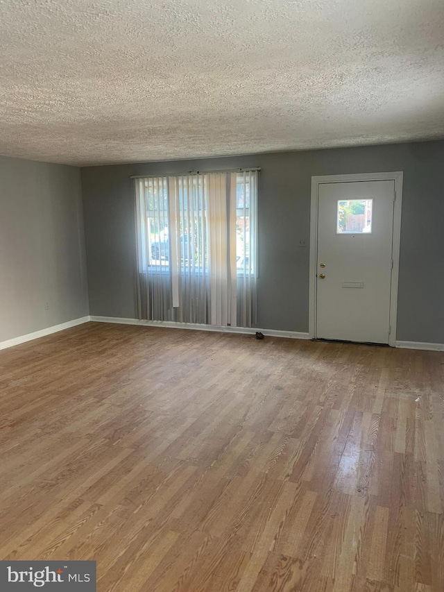 entrance foyer with hardwood / wood-style floors and a textured ceiling