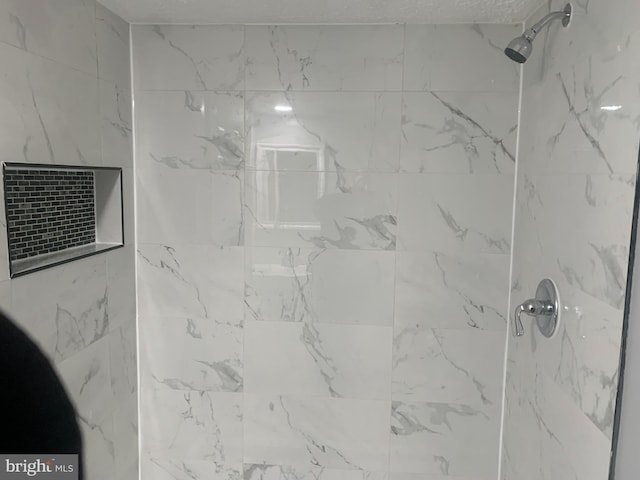 interior details with a tile shower