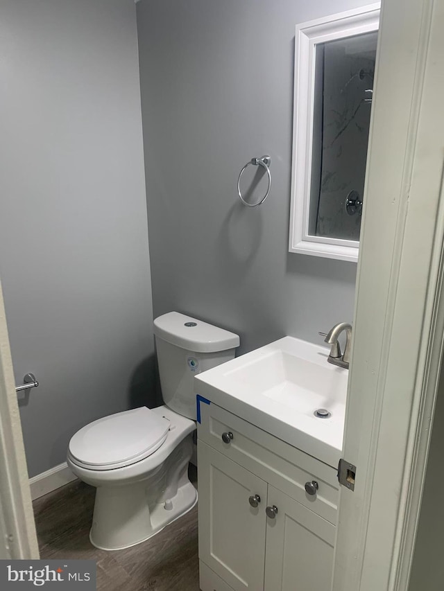 bathroom with vanity, wood-type flooring, and toilet