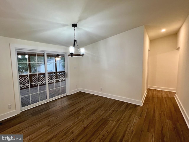 unfurnished dining area with a notable chandelier and dark hardwood / wood-style floors