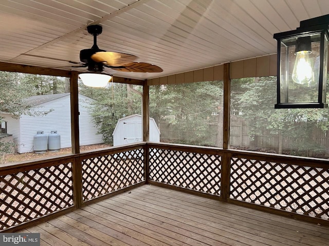 deck featuring ceiling fan and a storage unit