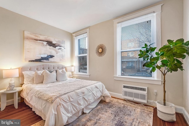 bedroom with wood-type flooring and an AC wall unit