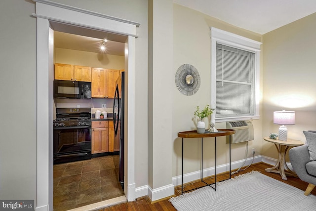 kitchen featuring dark hardwood / wood-style floors, cooling unit, and black appliances