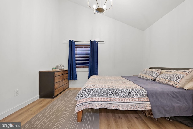 bedroom with hardwood / wood-style floors and lofted ceiling