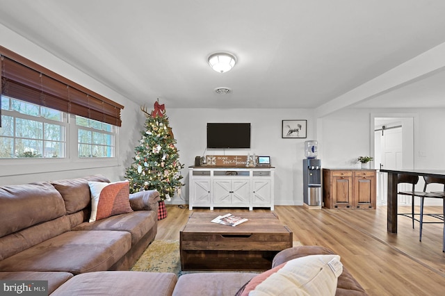 living room with hardwood / wood-style flooring and a barn door