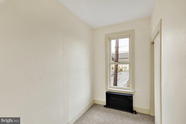 carpeted empty room with radiator