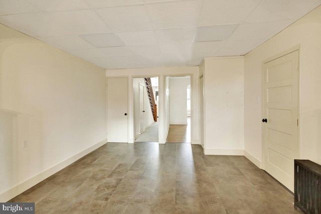 spare room with a paneled ceiling and radiator