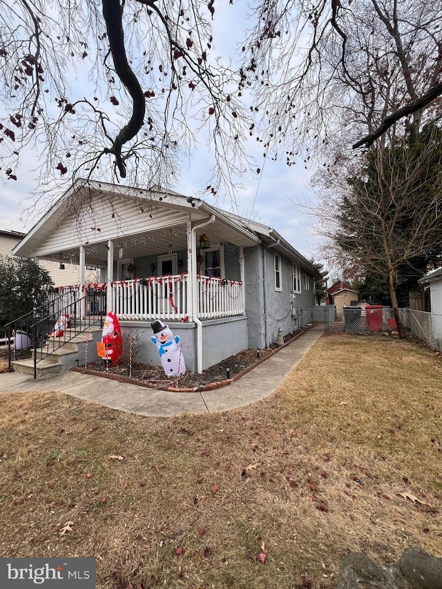 view of side of property with a porch and a yard