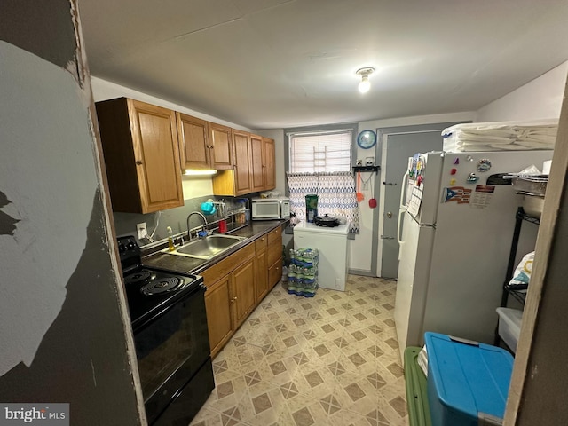 kitchen with sink, washer / clothes dryer, black range with electric cooktop, and white fridge