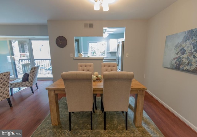 dining space with dark hardwood / wood-style floors and an inviting chandelier