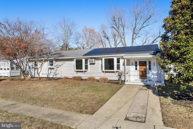 ranch-style house featuring a front yard and solar panels