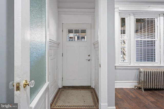 doorway with radiator heating unit and dark wood-type flooring