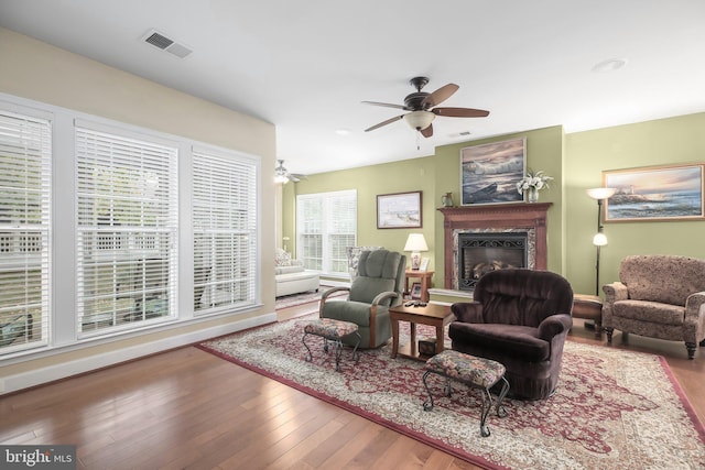 living room with ceiling fan, a fireplace, and hardwood / wood-style floors