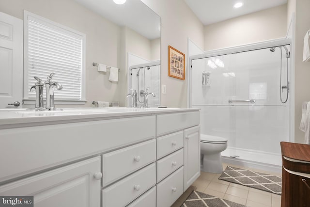 bathroom with toilet, tile patterned flooring, a shower with shower door, and vanity