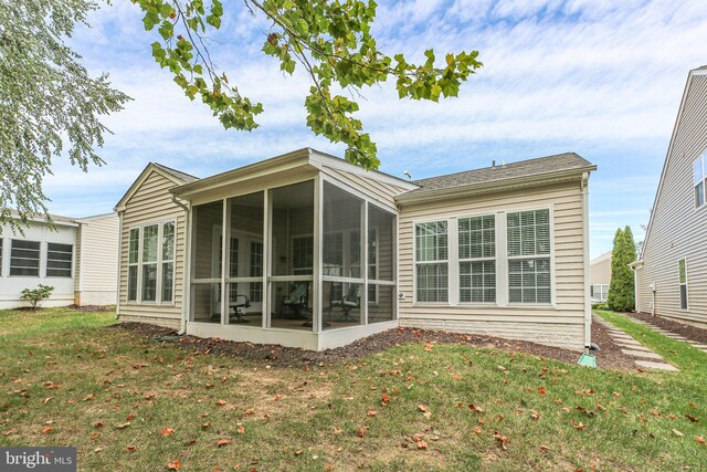 back of house with a lawn and a sunroom